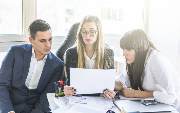 businesspeople-looking-document-office